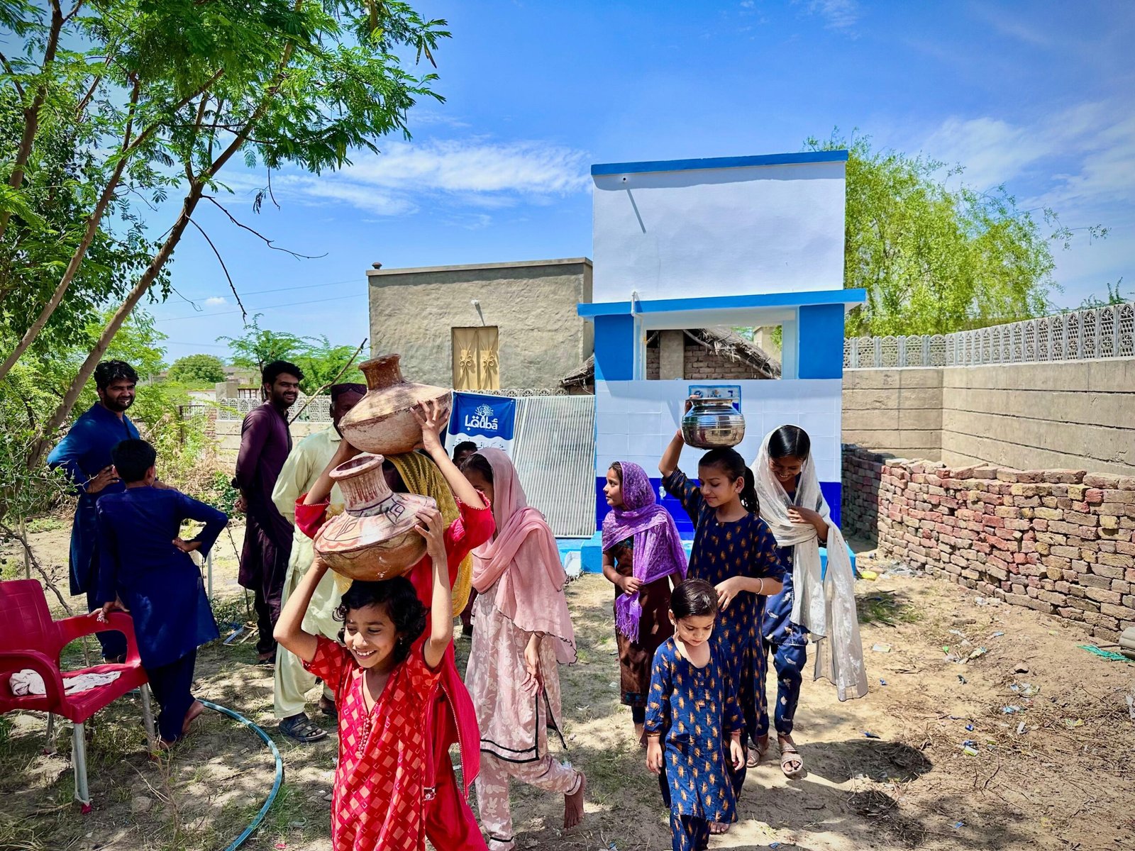 Children carrying water, community gathering.