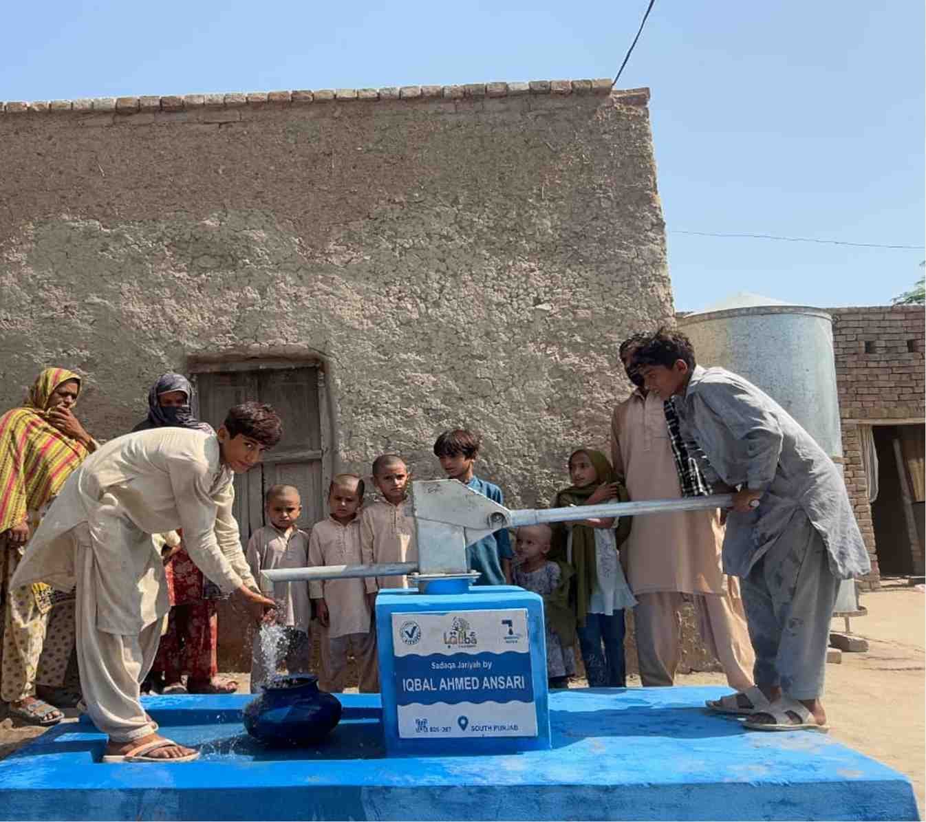Man collecting water from newly installed hand pump