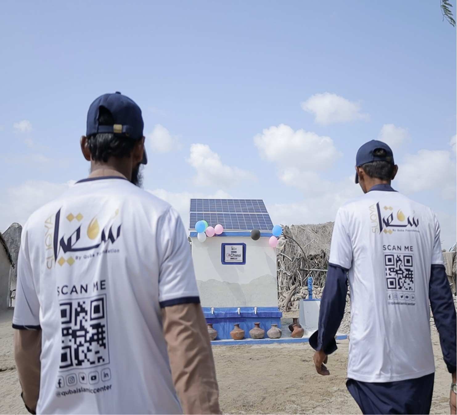 Quba Team volunteers standing beside water tank installation