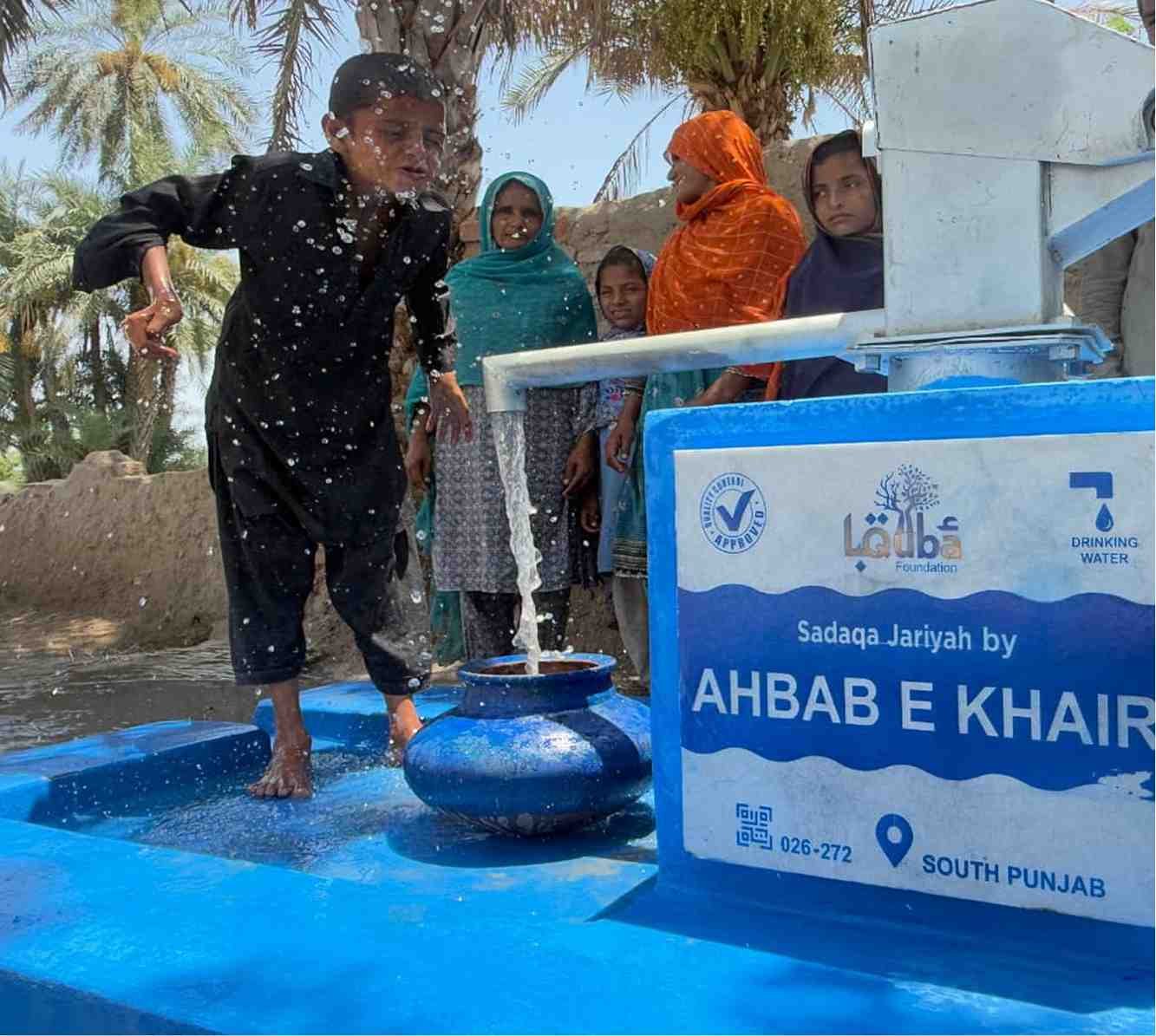 Boy filling water container at Suqya Waters installation