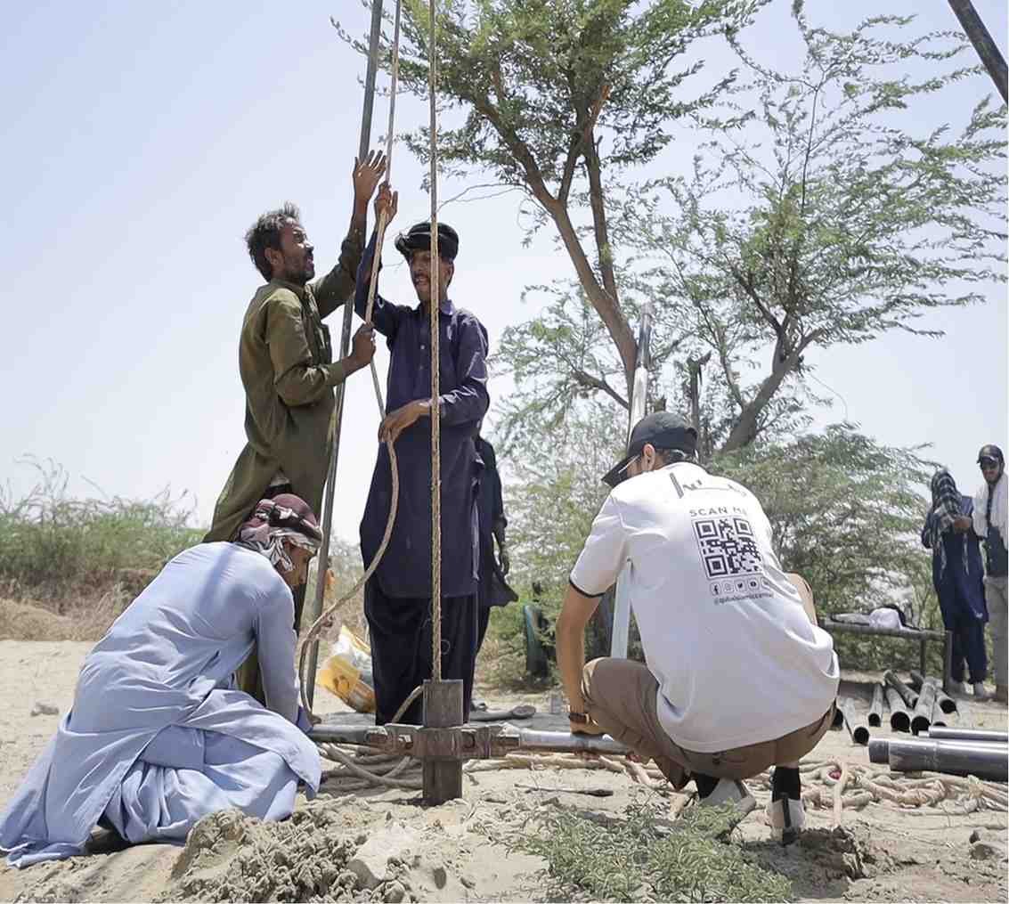 Men digging borehole for hand pump installation