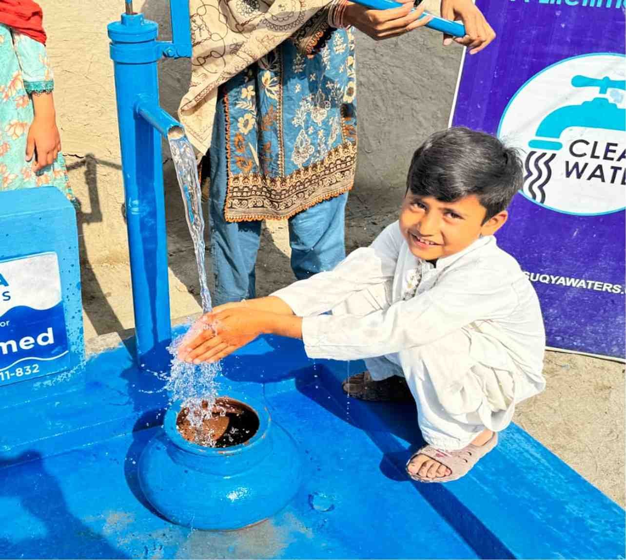 Boy filling water container at Suqya Waters installation